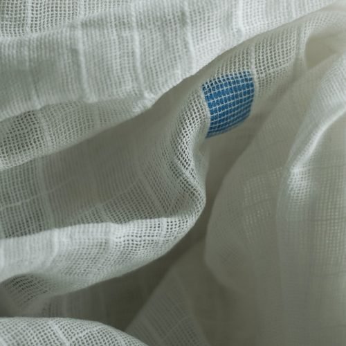 A close up of a white sheet with a blue dot on it