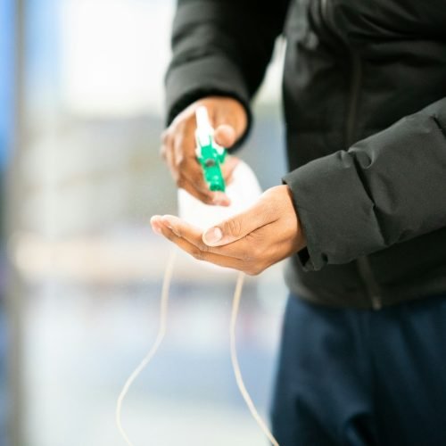 person in black jacket holding green and white plastic bottle